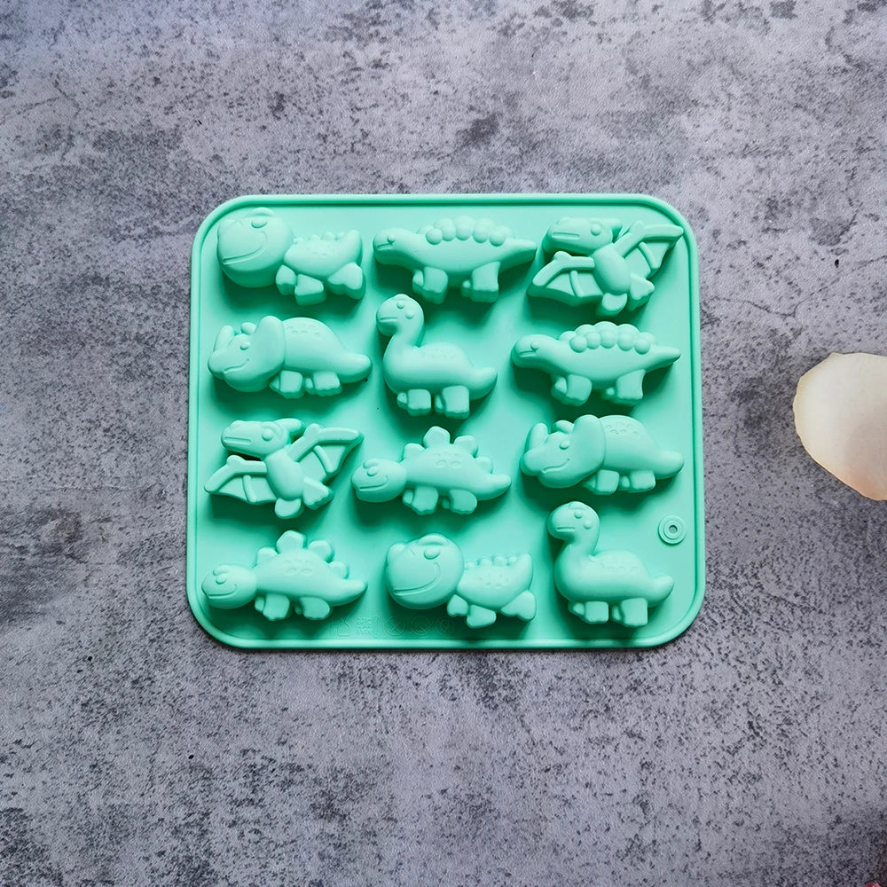 A silicone mold tray filled with green dinosaur shapes for baking, chocolate, and craft projects.