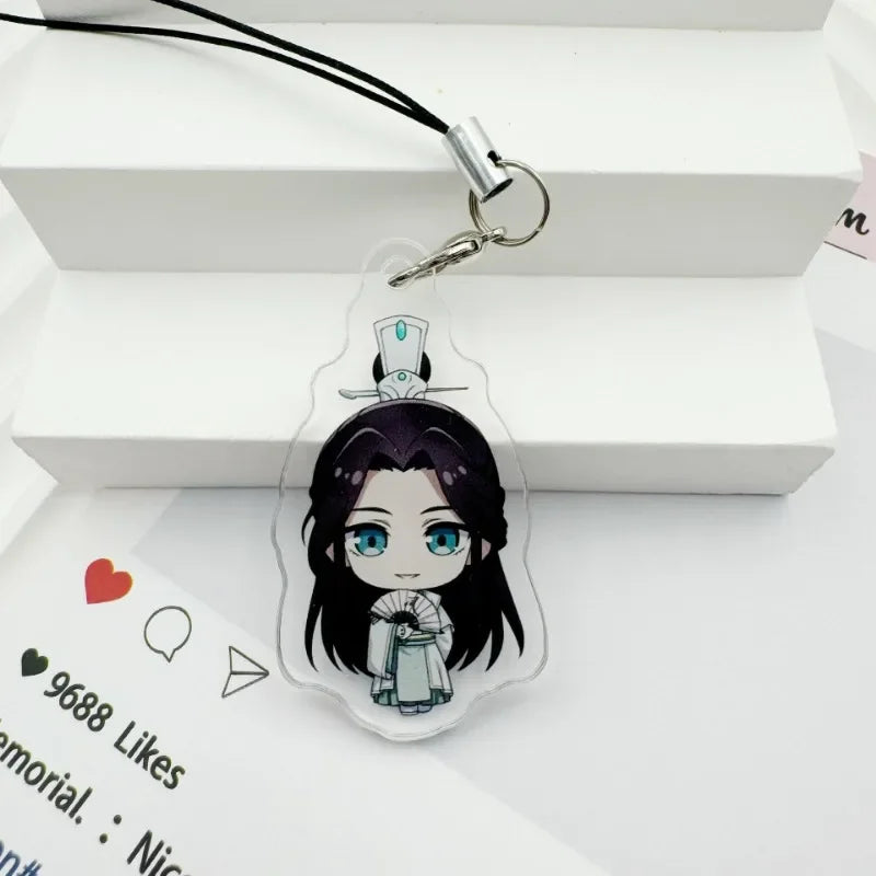 A clear acrylic pendant featuring a stylized character design attached to a black cord and metal keyring.