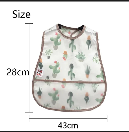 A white baby bib with a green cactus pattern and a brown trim, shown next to a measurement scale.