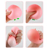 Hands squeezing a pink peach-shaped stress relief toy for relaxation