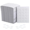 A stack of white pre-waxed cotton candle wicks with metal sustainer tabs and loose individual wicks.