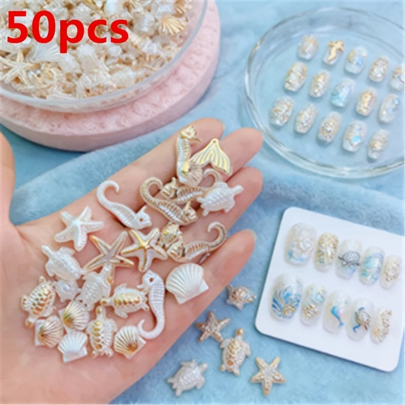 A hand displays a mix of white and gold ocean animal acrylic beads for DIY jewelry making.