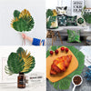 Artificial tropical palm leaves used as party decor, featuring green and gold leaves.