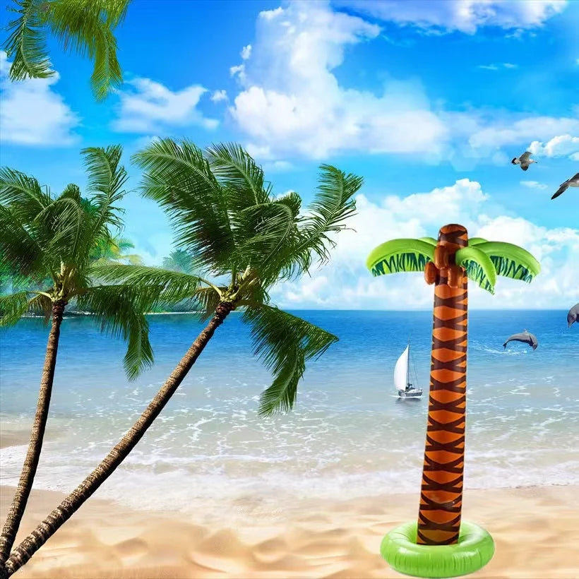 An oversized inflatable palm tree with green fronds and orange trunk stands in clear blue tropical water.