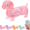 Un jouet squishy en dachshund rose et pailleté est présenté avec plusieurs autres jouets en dachshund colorés et pailletés.