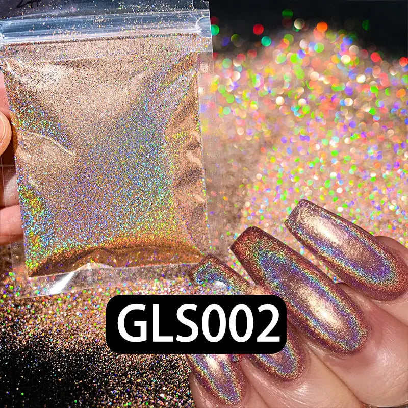 A hand holds a small bag of holographic rainbow nail glitter dust next to finished nails displaying the shimmer.
