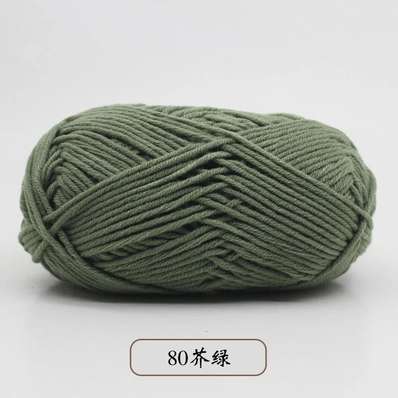 A ball of olive green pre-dyed milk cotton yarn, 80 strands thick, shown from the side.