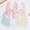A set of five soft cotton baby bibs in pastel pink, blue, white, and cream colors with adjustable snap closures.