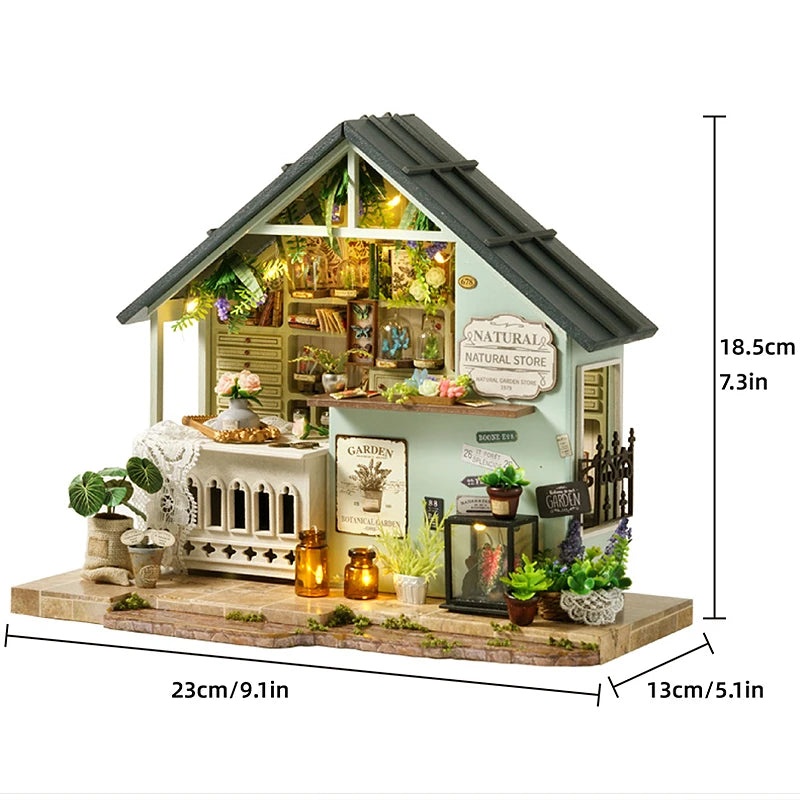 A miniature dollhouse kit featuring a rustic wooden house with warm lighting, furniture, and garden elements.