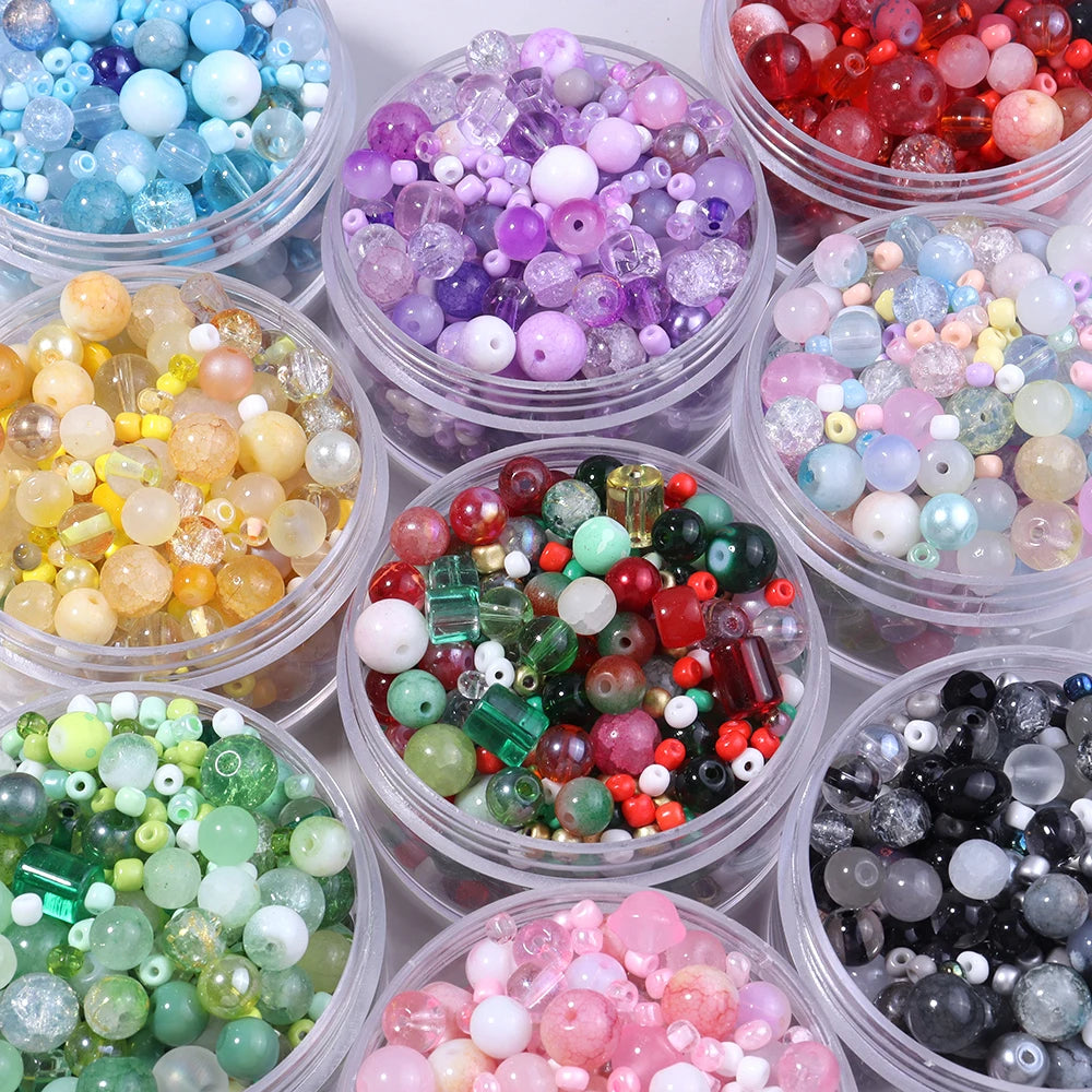 A collection of colorful glass beads in various shades including blue, purple, pink, and green for DIY jewelry making