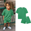 A green kids summer tracksuit set featuring a short sleeve top and matching shorts.