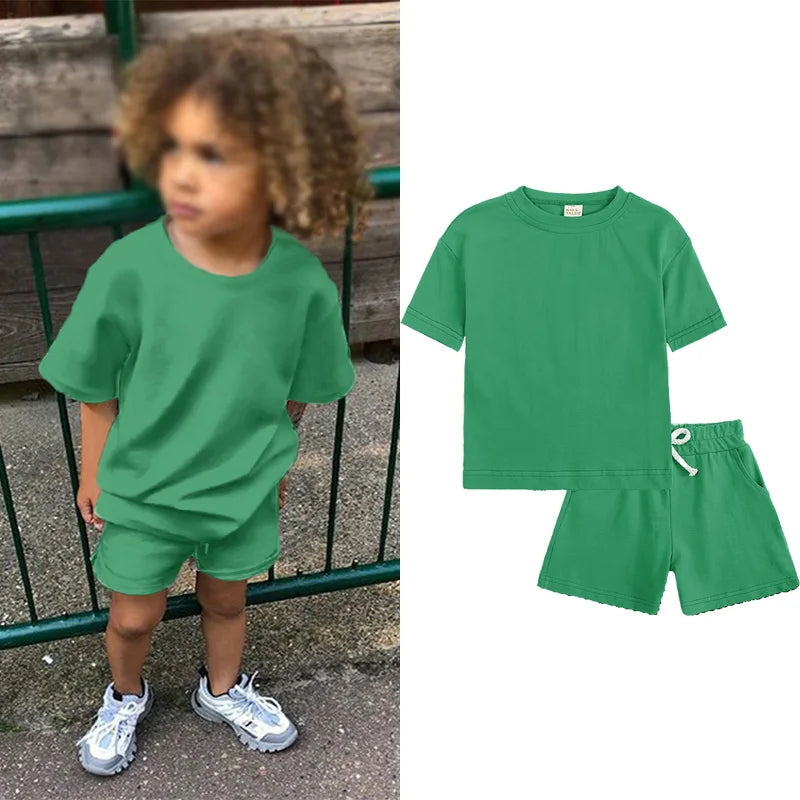 A green kids summer tracksuit set featuring a short sleeve top and matching shorts.
