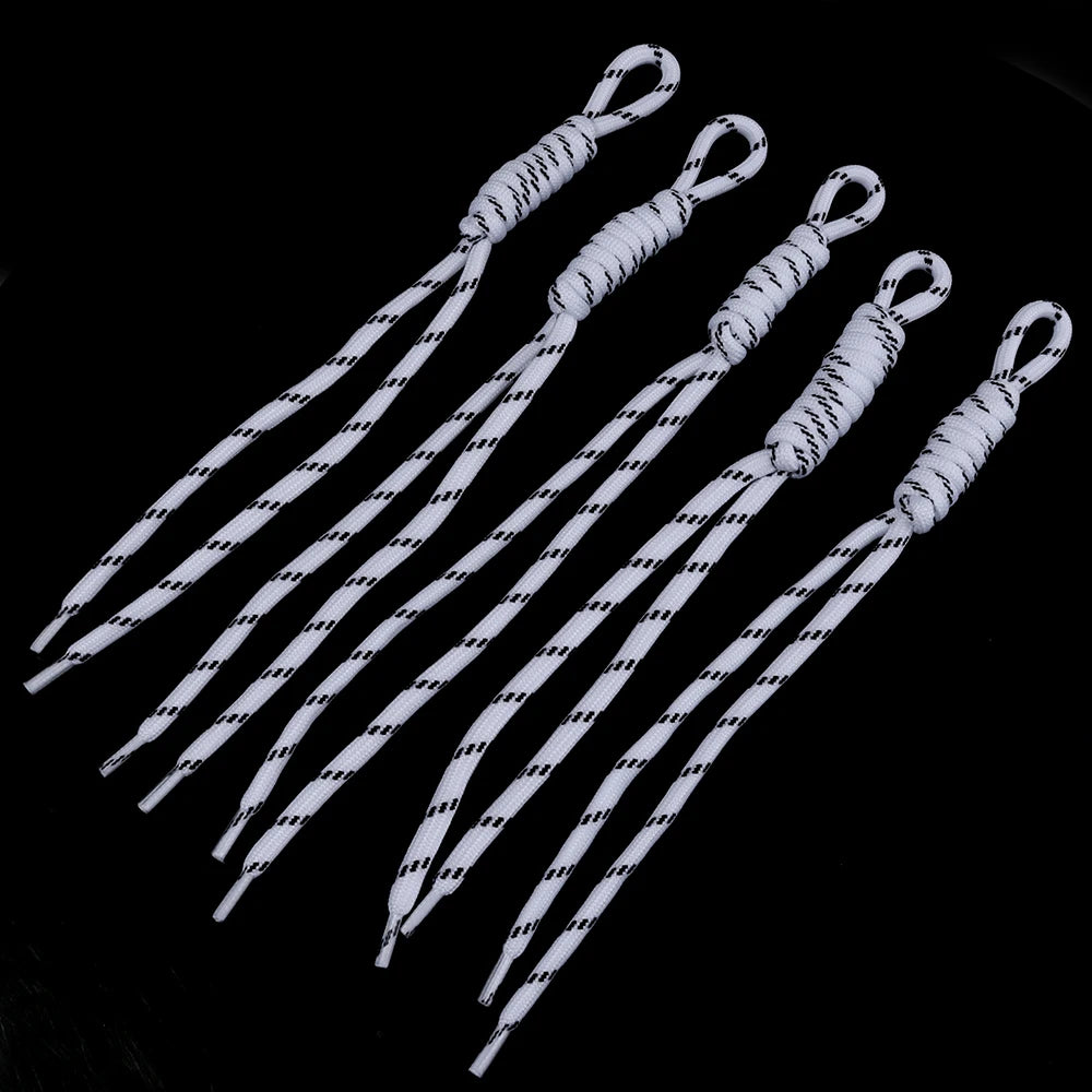 A collection of white and black striped braided lanyards or keychains arranged diagonally against a black background.