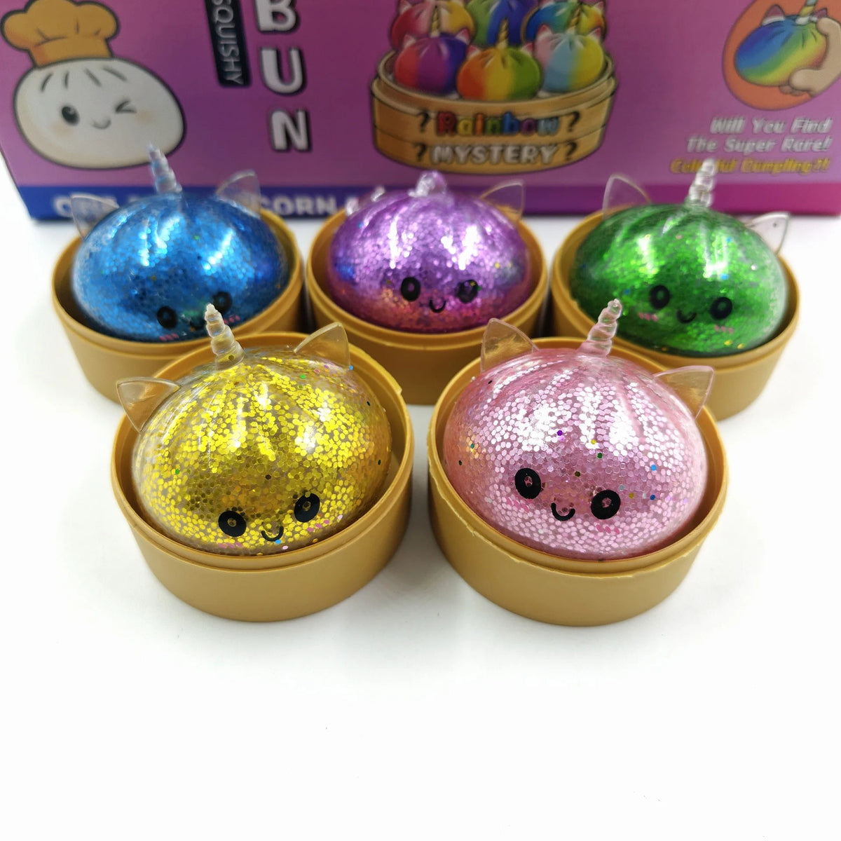 A set of seven glitter unicorn dumplings squishies in various colors packaged in a cardboard box.