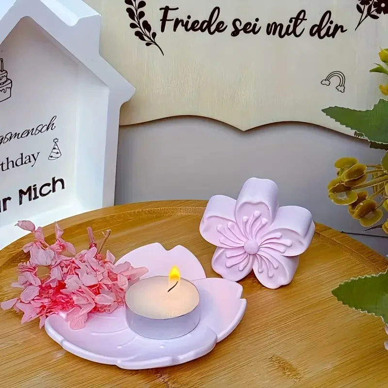 Pink silicone flower mold with a lit candle on a wooden surface against a wall sign