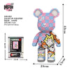 A colorful bear figure made of micro building blocks, featuring pink, blue, and white pieces.