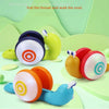A colorful musical pull-along snail toy with a thread for toddlers is shown on a light green surface.