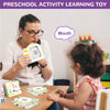 A woman demonstrates an interactive learning toy flash card to a young child in a classroom setting.