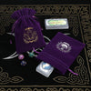 A purple velvet tarot card pouch with a drawstring closure, featuring gold embroidery and included tarot cards.