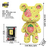 A yellow brick art bear figure made of small wooden blocks, packaged with instructions.