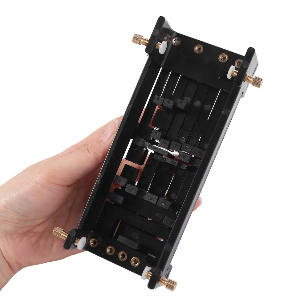A black beginner guitar chord trainer device is held in a hand, showing its internal tuning mechanism.