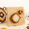 A wooden bamboo crochet blocking board with pins and stand displaying a finished crocheted item.