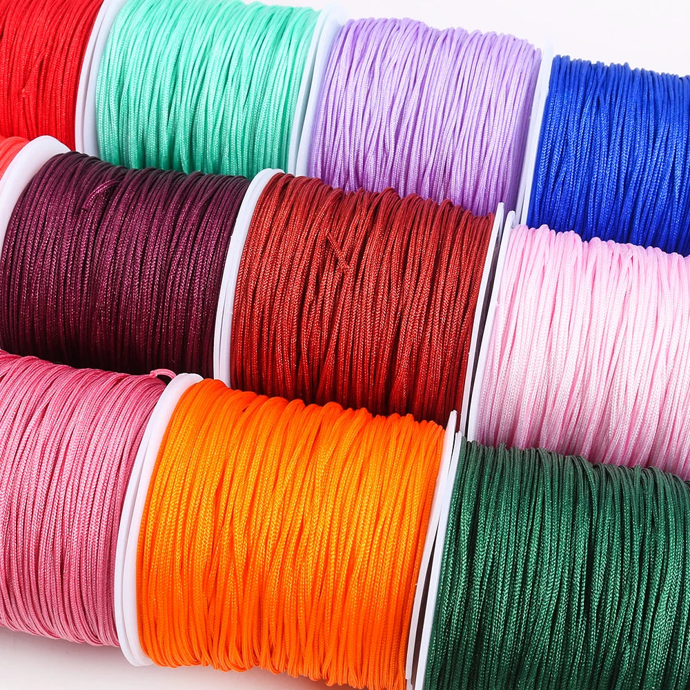 A collection of colorful macrame cord rolls in various shades including red, green, purple, and pink.