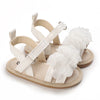 A pair of beige baby first walker sandals with white straps and soft anti-slip soles.