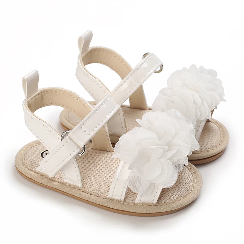 A pair of beige baby first walker sandals with white straps and soft anti-slip soles.