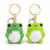 A pair of soft green crochet frog keychains with gold rings.
