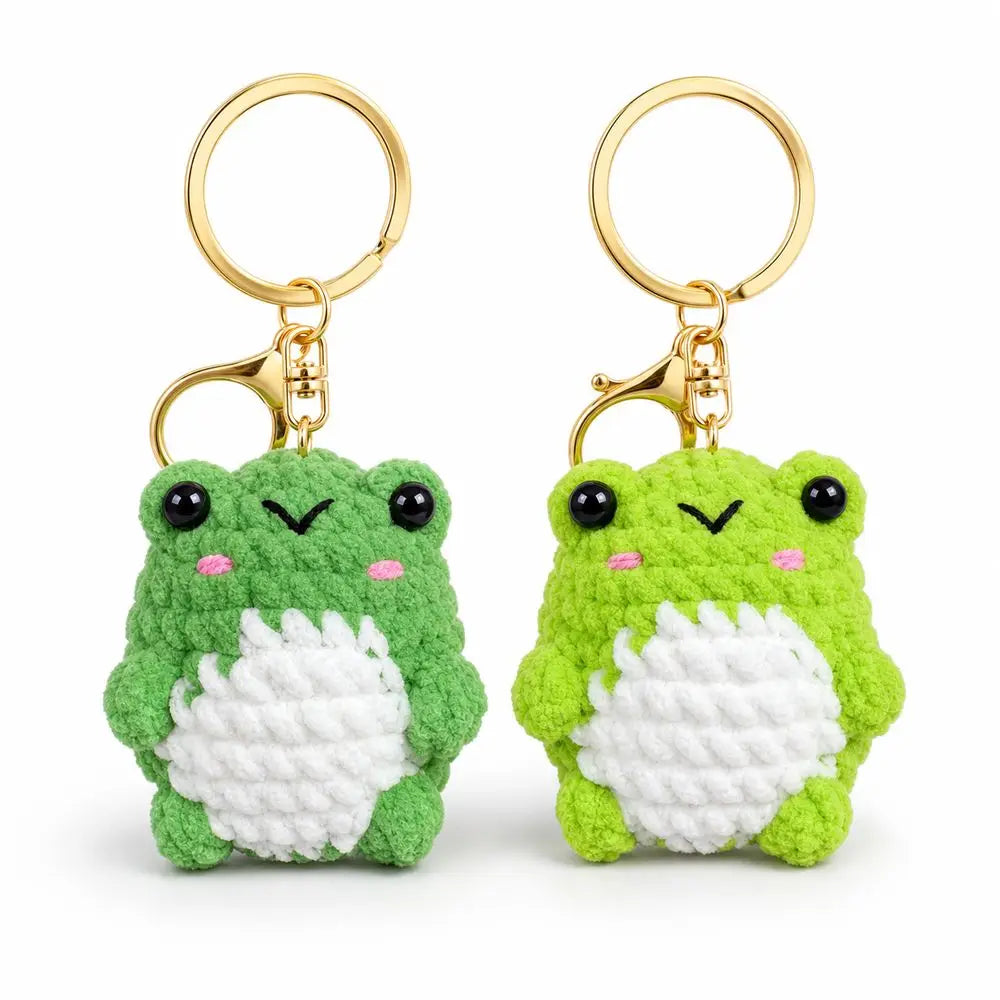 A pair of soft green crochet frog keychains with gold rings.
