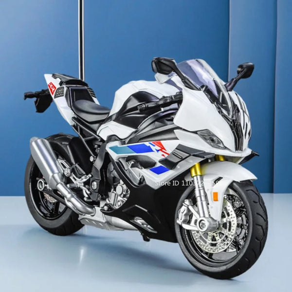 Model motorcykel i 1:12 skala i hvid og sort med forhjulsstyring på blå baggrund.