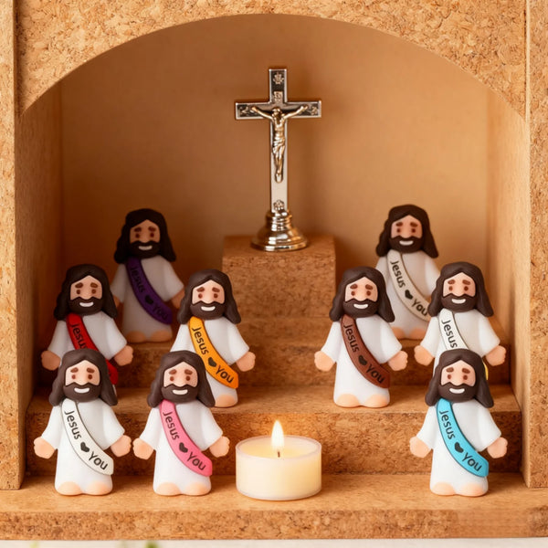 Ein Set Mini-Religiöse Statuen von Jesus und einem Kreuz, in einer Nische mit einer Kerze ausgestellt.