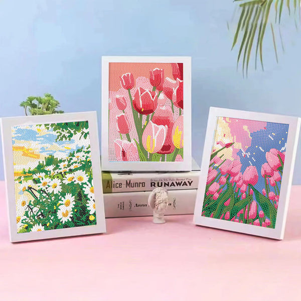 Three framed paintings featuring vibrant floral designs in pink, red, and yellow tones.