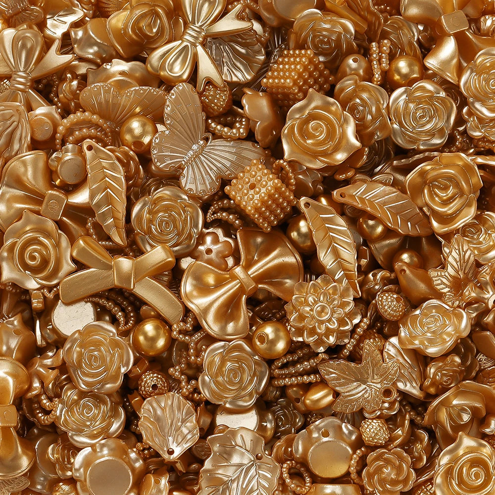 A close-up of various gold and bronze butterfly shell acrylic beads for DIY jewelry making.