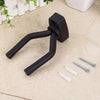 A black universal guitar wall mount hanger with threaded ends and mounting hardware lying on a light surface.