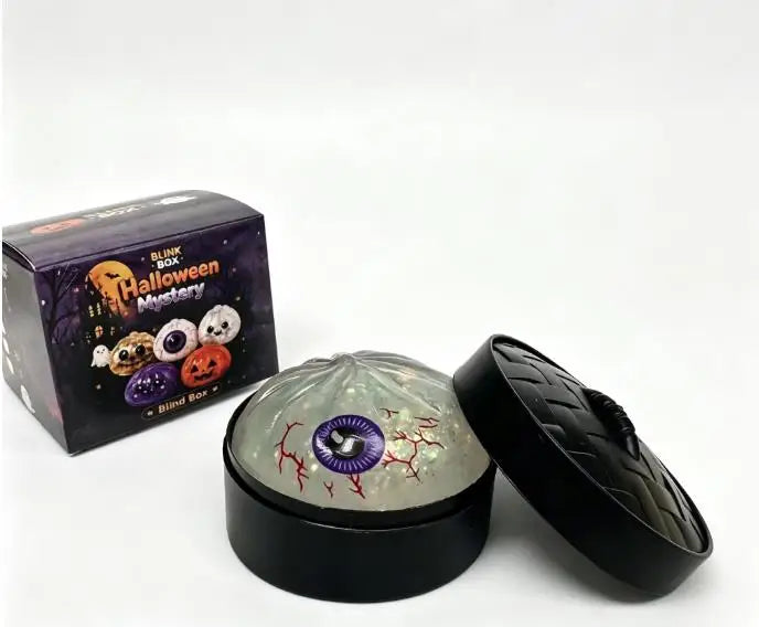 A black box of Halloween-themed squishy stress relief toys and an open black container with a translucent, glowing sphere.