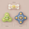 A set of three baby bath toys featuring a bear face, one green spinner, and one blue spinner.