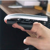 A hand holds a silver retractable mechanical wolf claw prop with black grips and flexible knuckles.