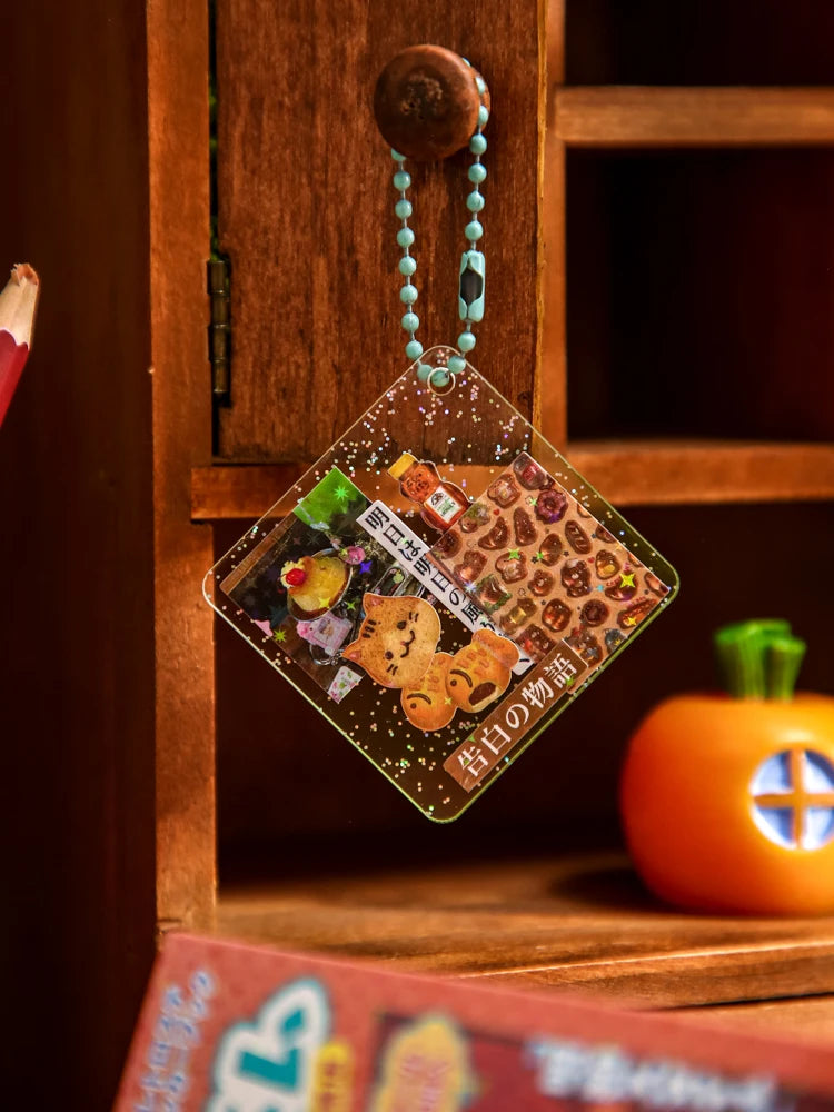 A square clear acrylic charm featuring various Japanese vintage kawaii stickers on a teal beaded necklace.