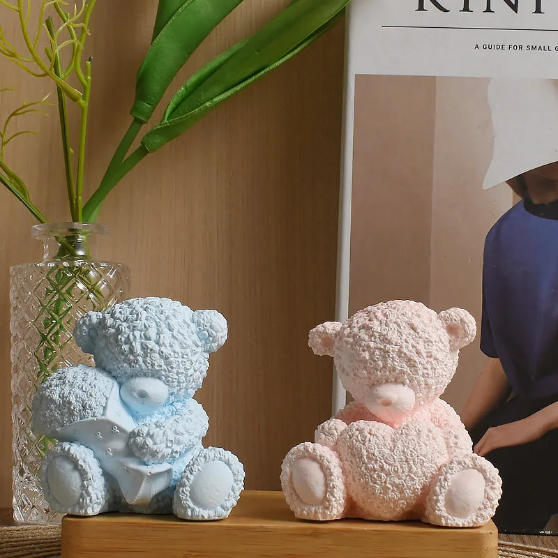 A light blue teddy bear hugging a pink heart, used as a silicone mold for candles and resin.