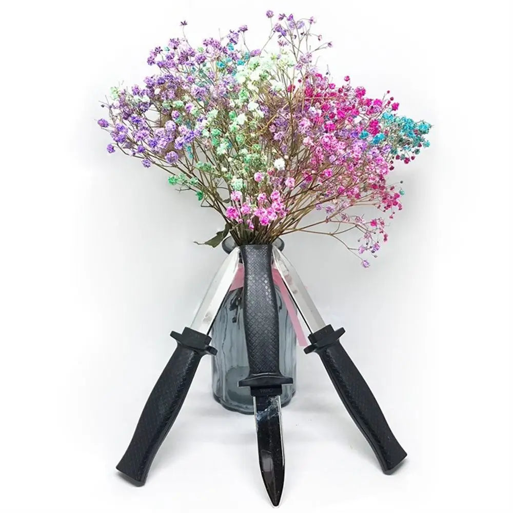 A bouquet of pink and purple flowers is displayed in a silver vase with black handles.