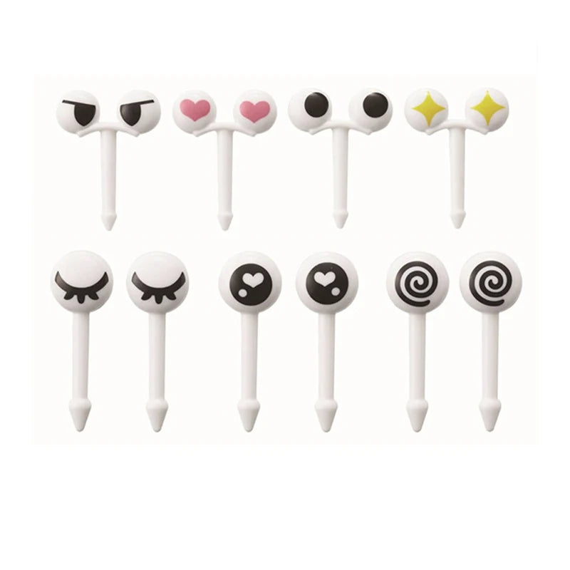 A set of ten white mini fruit forks with various cute face designs for kids