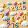 A collection of colorful silicone molds shaped like clouds, hearts, stars, and numbers for baking and crafts