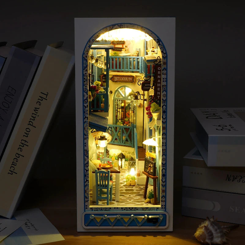 A DIY miniature bookshelf book nook kit featuring a detailed scene with wooden elements and LED lighting.