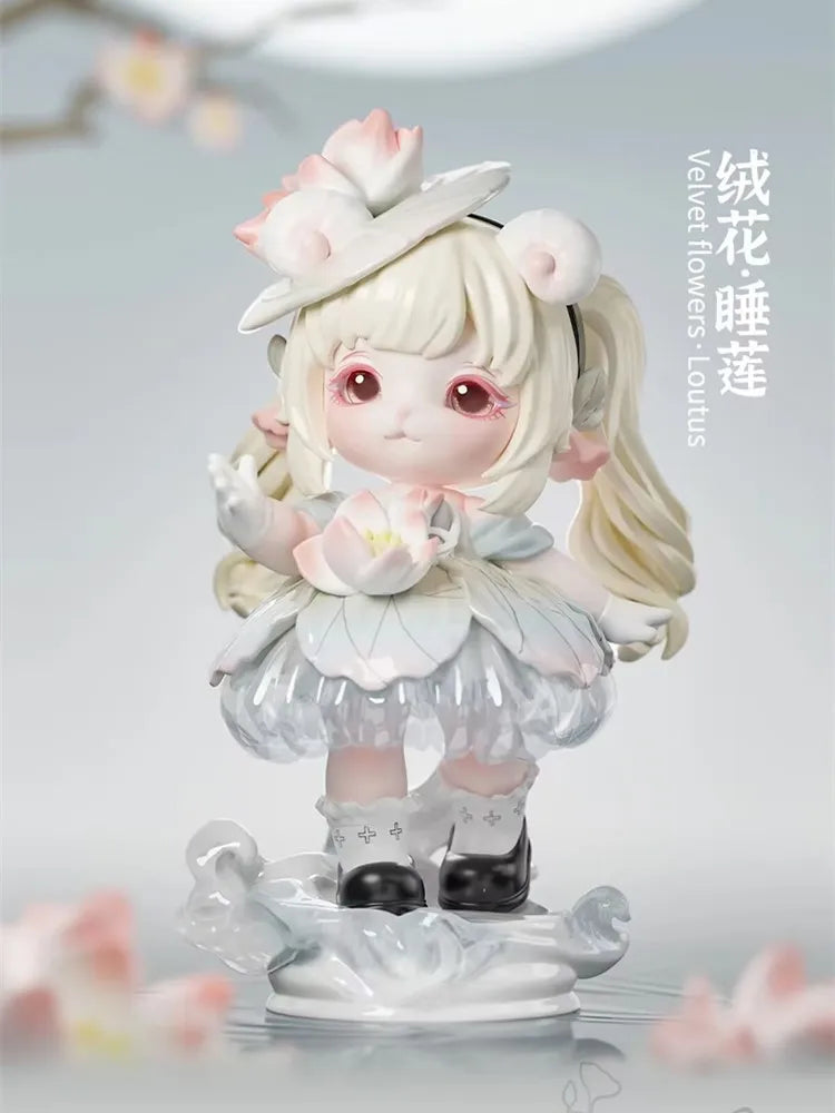A cute figurine of a girl with long blonde hair and pink accents, wearing a white hat and dress, displayed on a clear base.