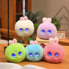 Three fluffy plush rabbit pendants in green, blue, and pink colors displayed on a wooden surface.