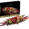 A dried flower centerpiece arrangement featuring roses and various floral elements displayed in a box.