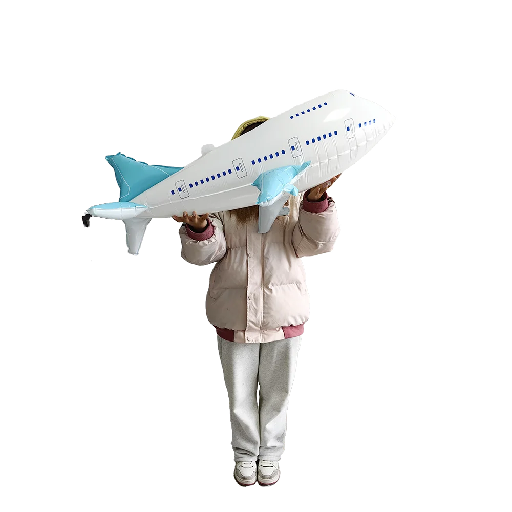 A person is holding a white foil balloon plane decorated with blue accents, posing for a photo.