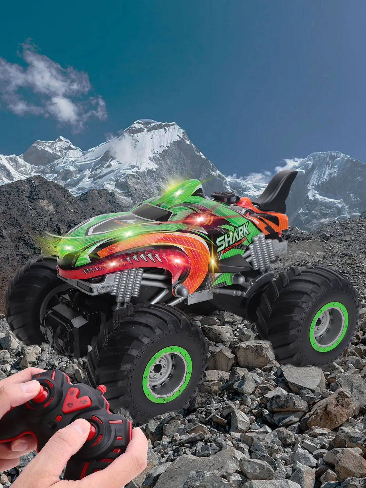 An All-Terrain RC monster truck in green and orange is shown on rocky terrain under a blue sky.
